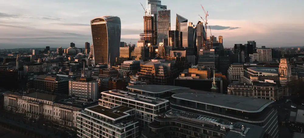 London from above at dusk: the towers of the City, the Walkie-Talkie and the Cheesegrater above the older streets