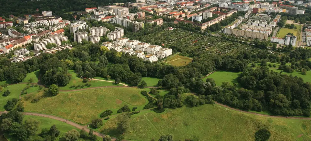 München von oben: Schwabing, die dichte Stadt und am Horizont die Alpen unter einem Gewitterhimmel